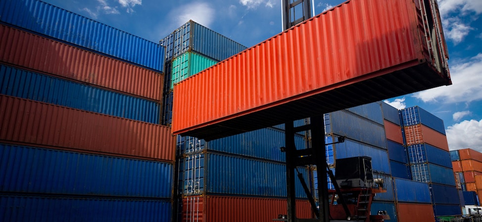 Stacked shipping containers with crane lifting container